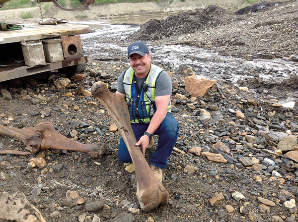 Placer miner Guy Favron holds a woolly mammoth femur found along Last Chance Creek. Photo courtesy of Government of Yukon