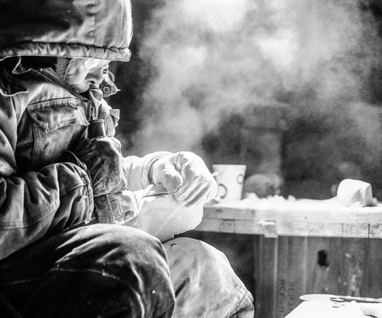 Billy Kuksuk of Arviat,  Nunavut carves a wolf outside his house in a -30 C windchill for an executive from Agnico Eagle's Meadowbank Mine. Photo by Paul Aningat 