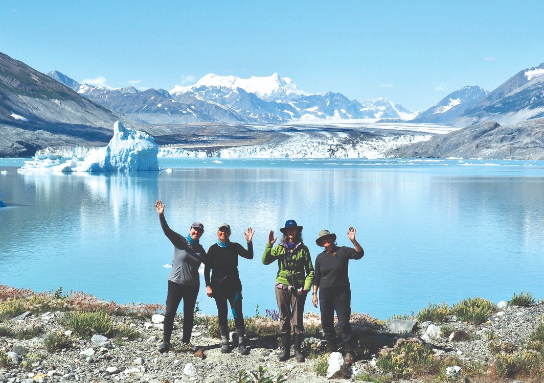 Bronwen Duncan, Jill Pangman, and others wave in front of Lowell Lake in Kluane National Park.