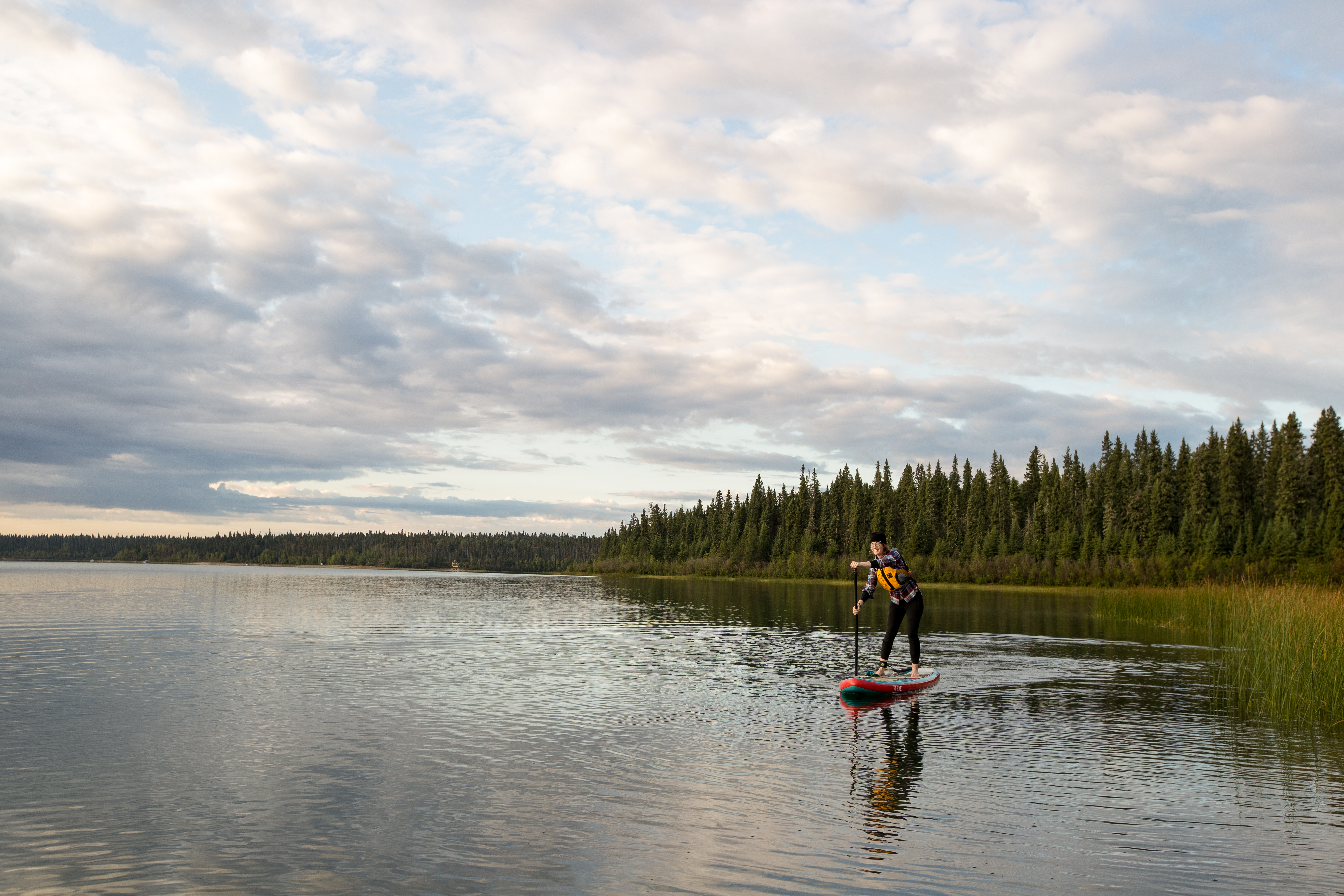 A stand-up paddle boarder enjoys the tranquil waters of Pine Lake. 