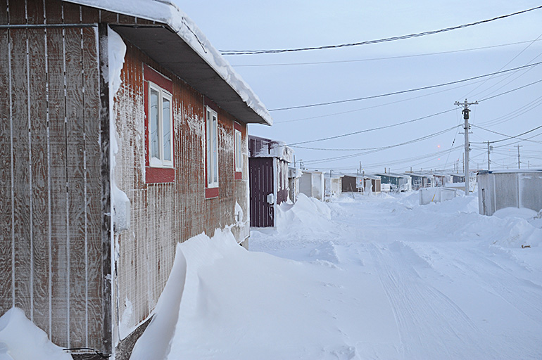 A line of houses on a snowy road. Photo by Herb Mathisen