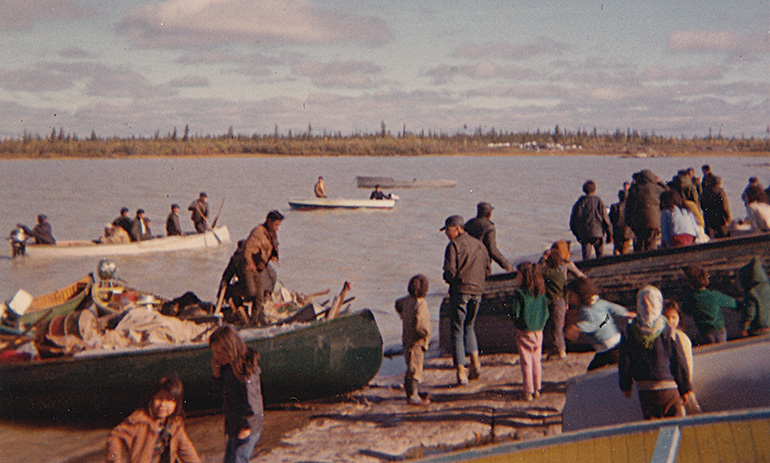 Village people help hunters offload caribou and gear