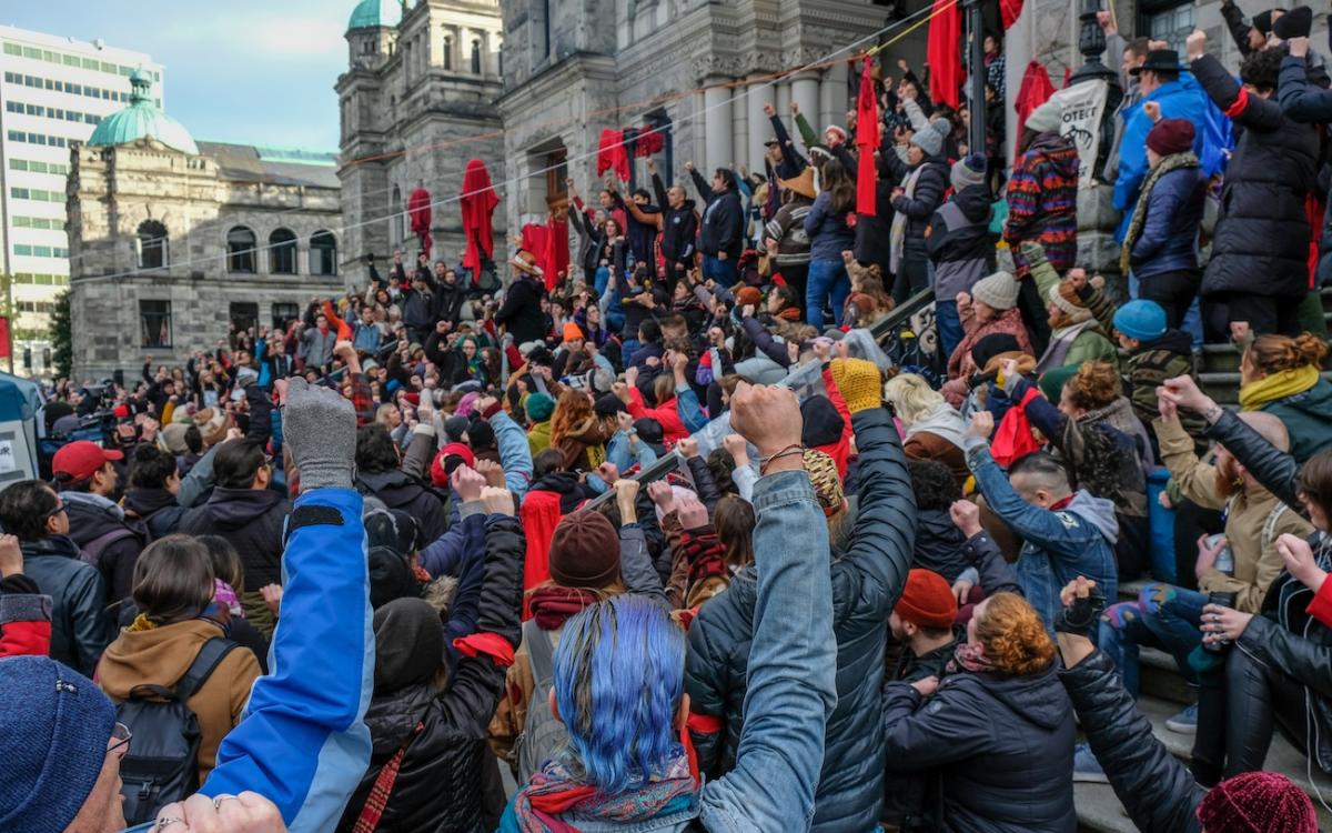 Gathering on the steps of the BC Legislature ahead of the 2020 throne speech, fists raised in the air. 