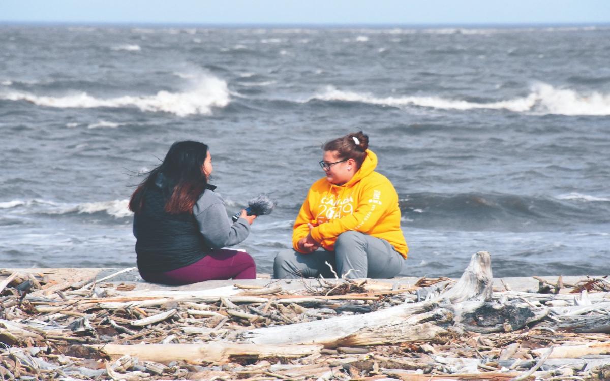 Mataya Gillis and Cassidy Lennie-Ipana talking on the shore. 