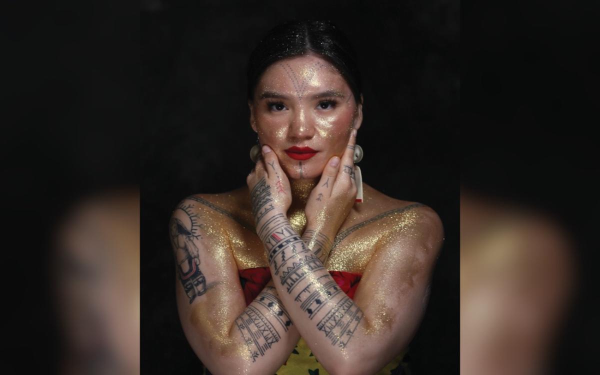 Arsaniq Deer modelling her tattoos and gold paint