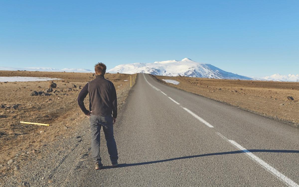Man standing on road waiting for a bus