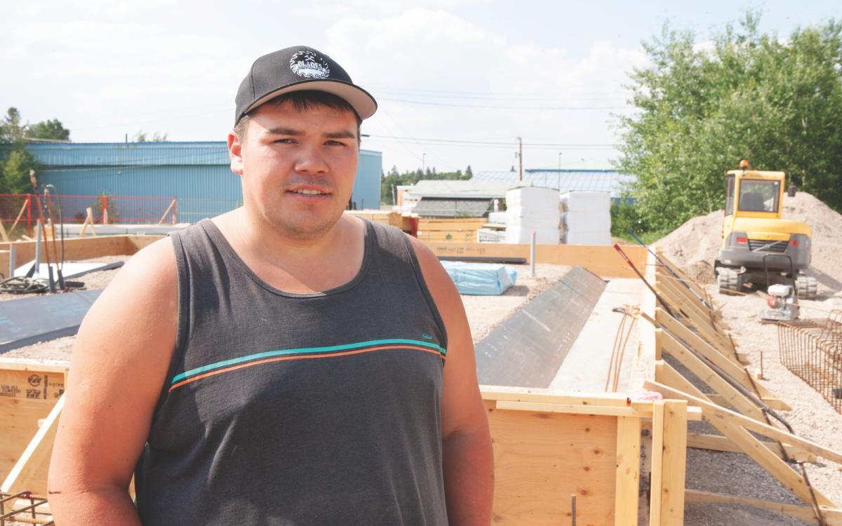 Jeremy Beamish stands in front of a work site