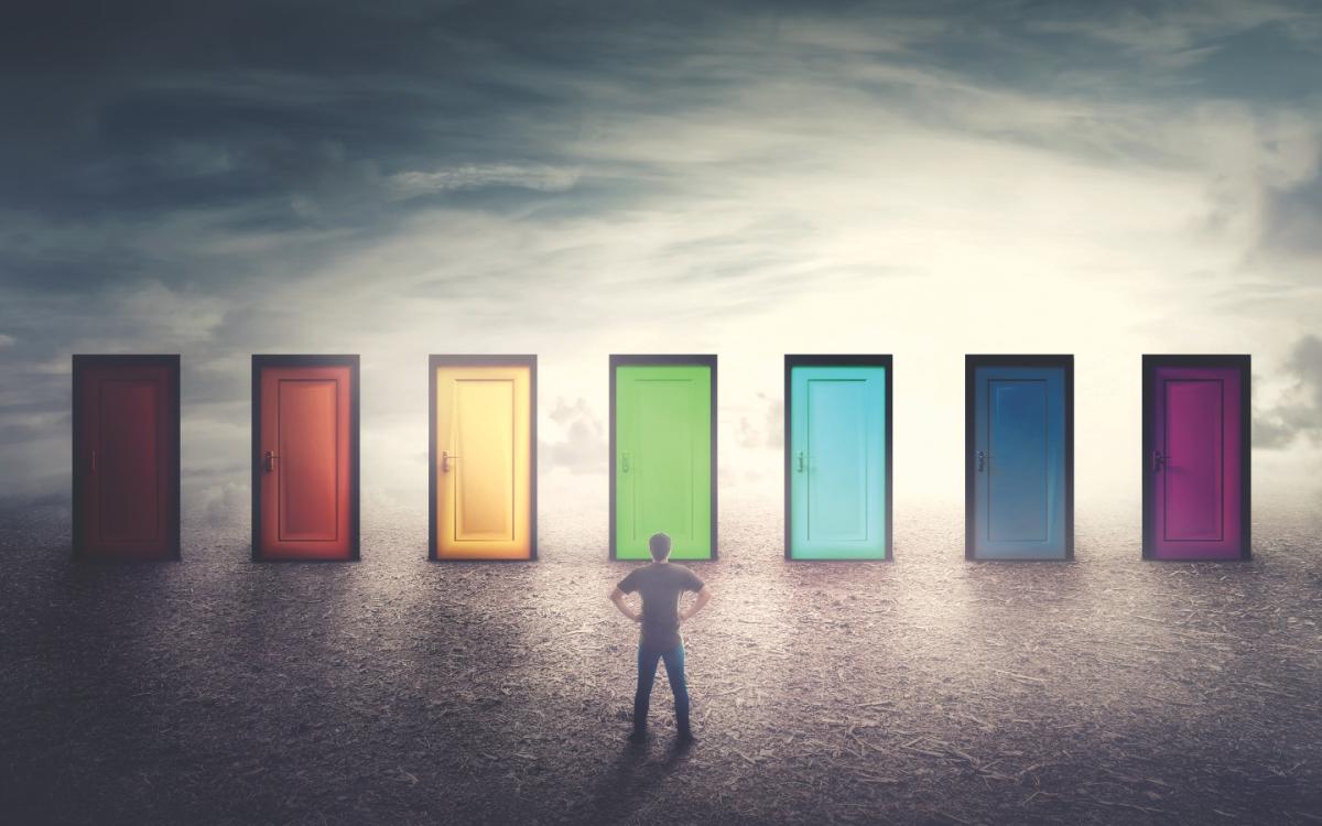 Man looking at multiple colourful doors.