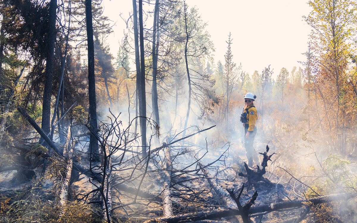 Kiah Vail hoses down a hot spot in the forest near Fort Smith