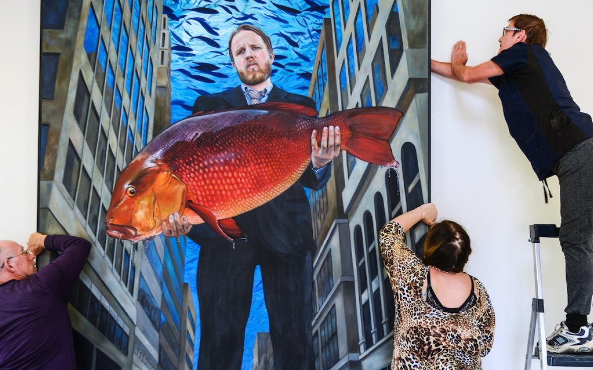 Ken Thomas, Crystal Carvill, and Sandra Storey install Suzanne Paleczny's piece, “Man Was a Fish, 2017,” during an exhibition at Art House Carcross. 