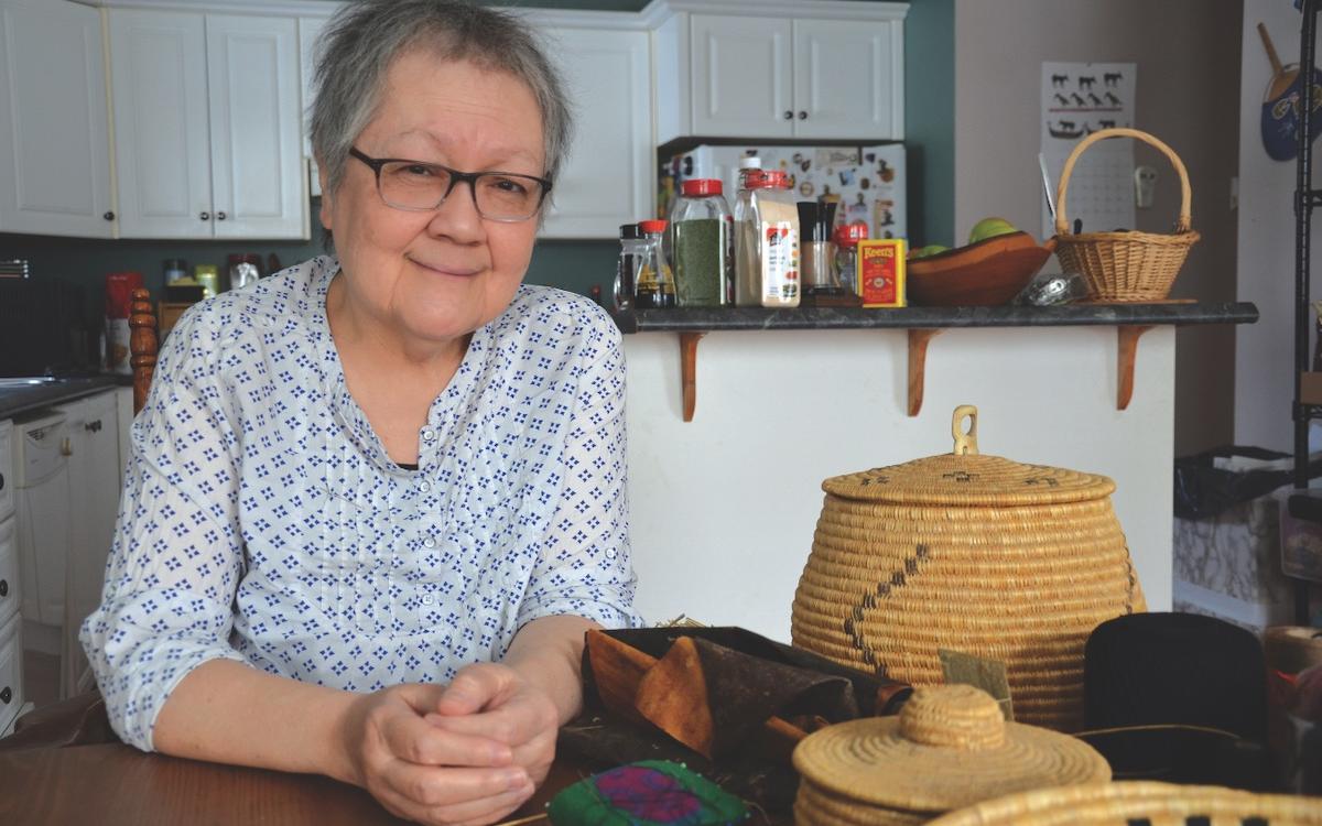 Margaret Lawrence at home in her kitchen, surrounded by some of her hand-sewn grass baskets. 