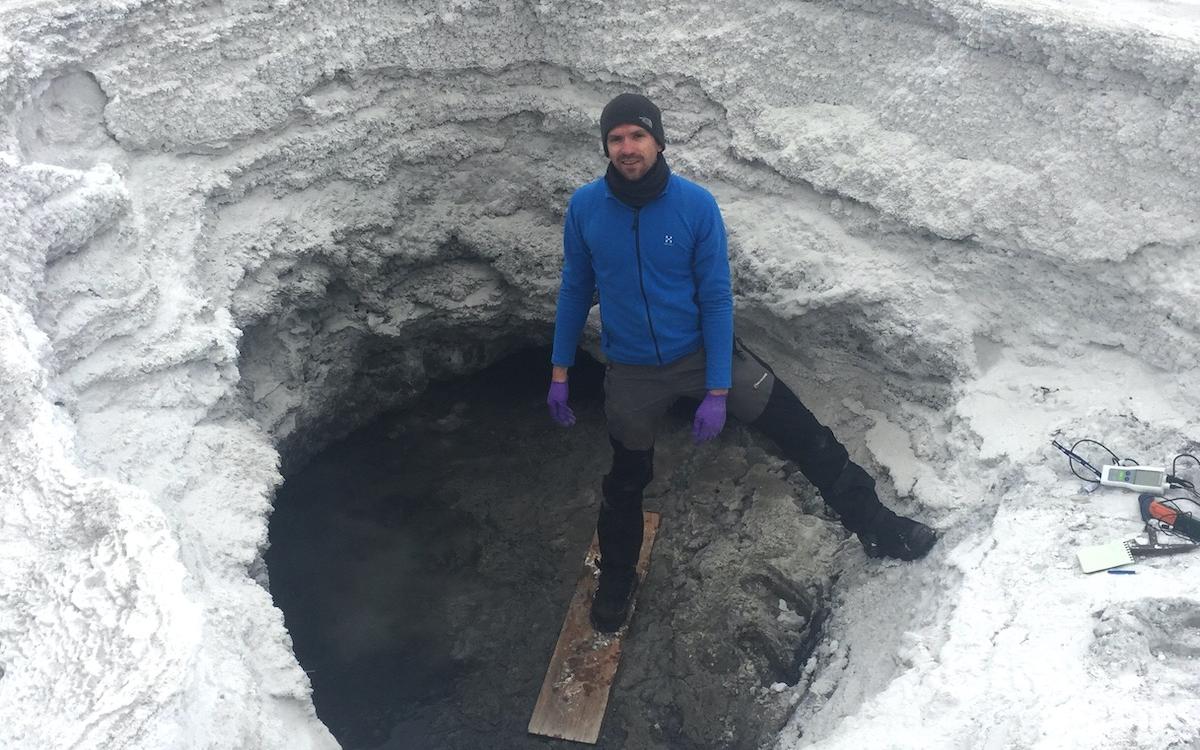Researcher Mark Fox-Powell stands at the entrance of the lost hammer spring on Axel Heiberg Island, where he studies potential conditions for life on other planets. 
