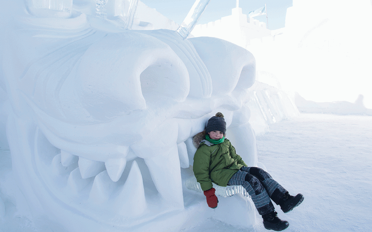 SNOW WONDER:  Sitting in the jaws of a  larger-than-life snow monster at the  SnowKing castle on Yellowknife Bay. Photo by Fran Hurcomb