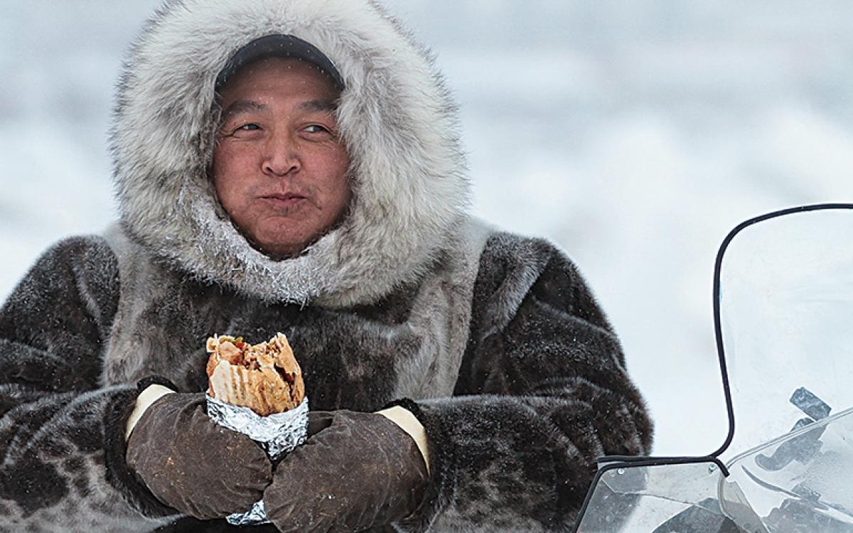 An Iqaluimmiut man chows down on a chicken wrap from Yummy Shwarma. Photo by Scott Wright