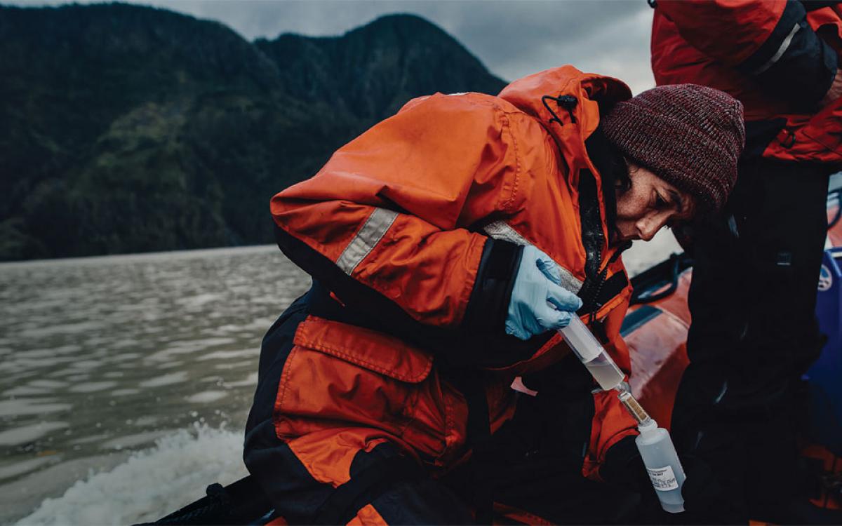 Scientists take a water sample during the Canada C3 trip last summer, as part of one of the largest eDNA surveys ever conducted. Later, this sample will be analyzed and the DNA it contains will paint a picture of the species present in the area. Courtesy Students on Ice Foundation/Taylor Roades