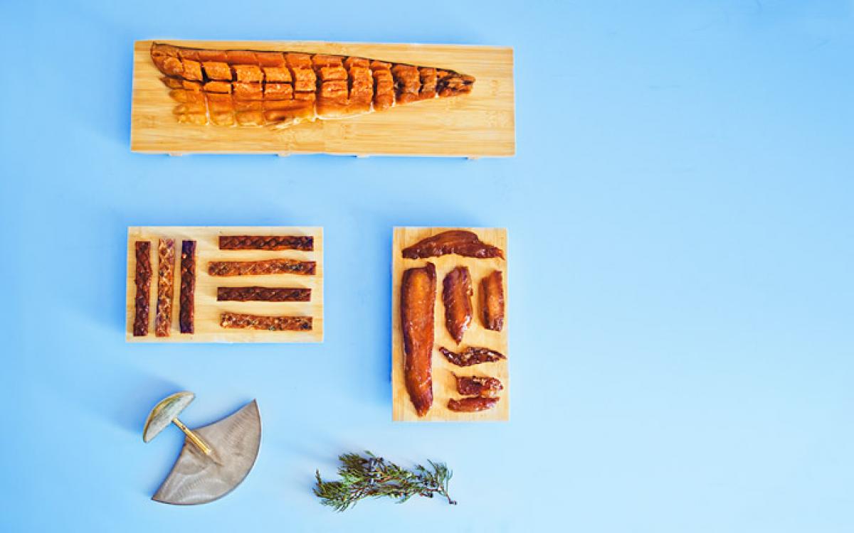 Clockwise: traditional pipsi, caught, brined dried and voila—the essence of char; candied char belly, brined with brown sugar, it melts in your mouth; mesquite and regular flavoured char sticks, for fish-lovers on the go. Photo by Angela Gzaowski