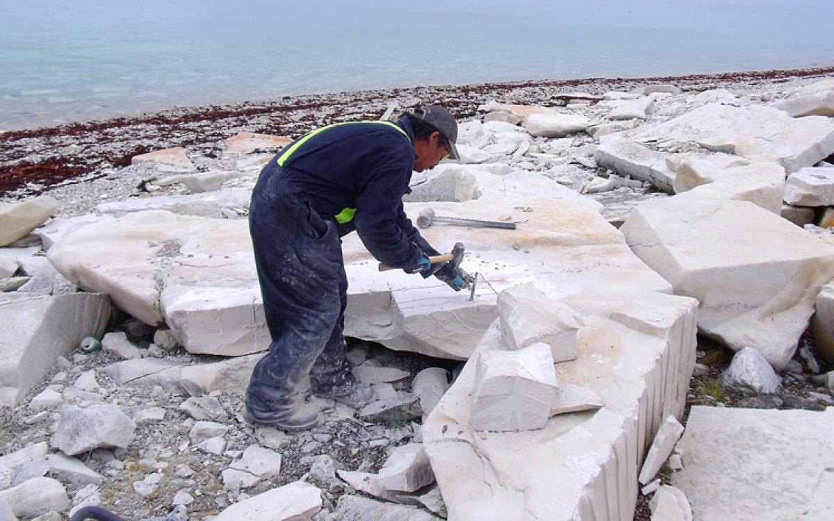 Carver Jerry Ell breaks out blocks of limestone on Bear Island, near Coral Harbour, Nunavut. Photo courtesy Government of Nunavut