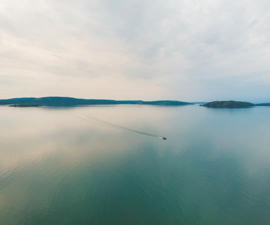 A small boat glides across Great Slave Lake. 