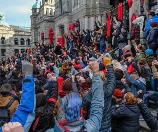 Gathering on the steps of the BC Legislature ahead of the 2020 throne speech, fists raised in the air. 