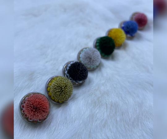 A line of colourful tufted earrings made by Alyssa Ross