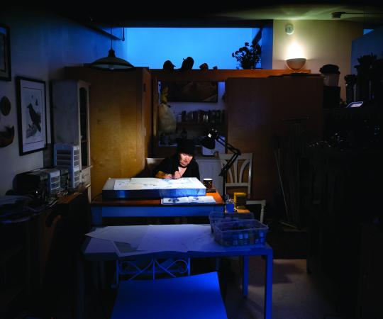 Inuk master artist Germaine Arnaktauyok, working on a piece in her home