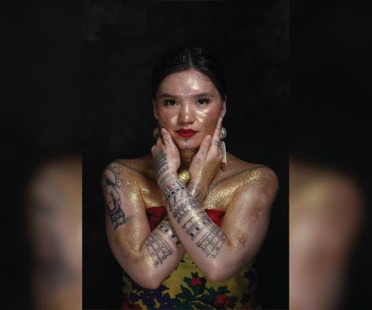 Arsaniq Deer modelling her tattoos and gold paint