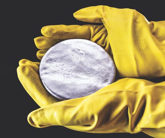 Gloved hands holding uranium