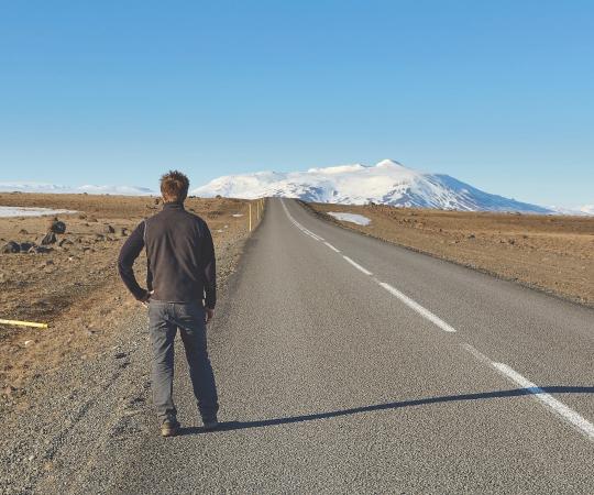 Man standing on road waiting for a bus