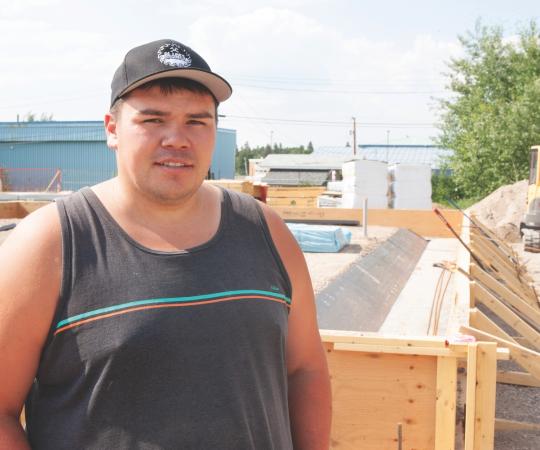 Jeremy Beamish stands in front of a work site