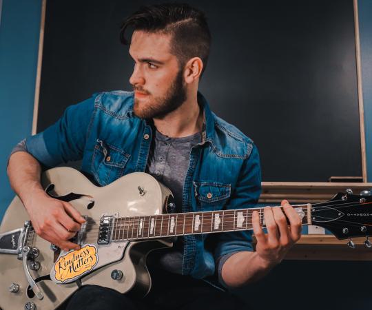 Elijah Bekk playing his guitar