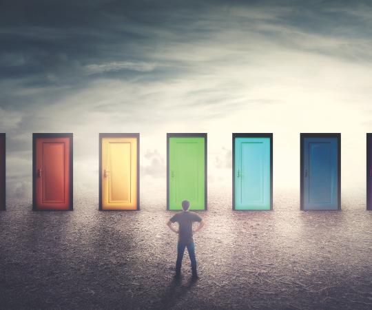 Man looking at multiple colourful doors.