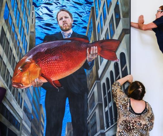 Ken Thomas, Crystal Carvill, and Sandra Storey install Suzanne Paleczny's piece, “Man Was a Fish, 2017,” during an exhibition at Art House Carcross. 