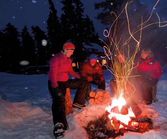 Cabin-dwellers around the fire. Photo courtesy of Fritz Mueller/Government of Yukon