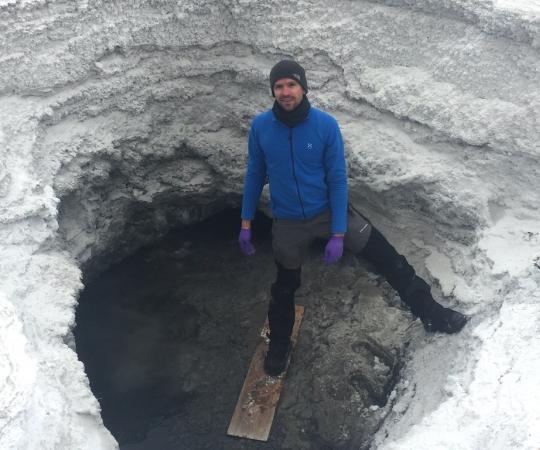 Researcher Mark Fox-Powell stands at the entrance of the lost hammer spring on Axel Heiberg Island, where he studies potential conditions for life on other planets. 