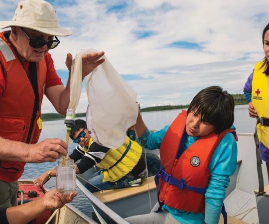 TESTING THE WATERS: Students learn how to check what's in their water, out in a boat on the Mackenzie River. Photo by Patrick Kane