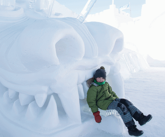 SNOW WONDER:  Sitting in the jaws of a  larger-than-life snow monster at the  SnowKing castle on Yellowknife Bay. Photo by Fran Hurcomb