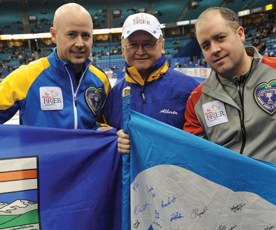 Kevin Koe, left, and Jamie Koe, right, pose with their father Fred at the Brier in Saskatoon in 2012, when the two brothers faced off in the playoffs. 