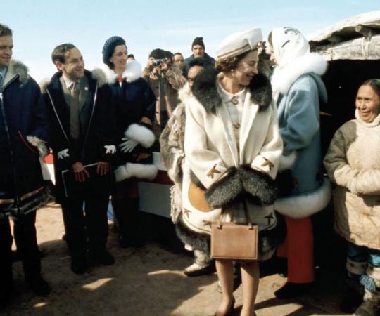 Queen Elizabeth II speaks to an Inuk woman during her 1970 visit to the NWT, and Jean Chretien (then minister of Indian and Northern Affairs) cracks a smile. Photo by Doug Griffin/Cp Images.