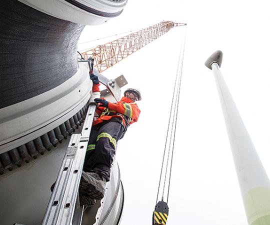 Workers erect one of the four 2.3-megawatt turbines now churning out energy at the Diavik diamond mine in the NWT. Photo courtesy of Rio Tinto (DDM)