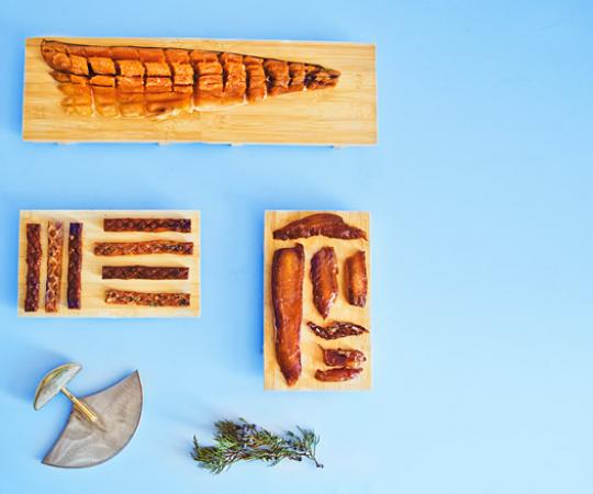Clockwise: traditional pipsi, caught, brined dried and voila—the essence of char; candied char belly, brined with brown sugar, it melts in your mouth; mesquite and regular flavoured char sticks, for fish-lovers on the go. Photo by Angela Gzaowski